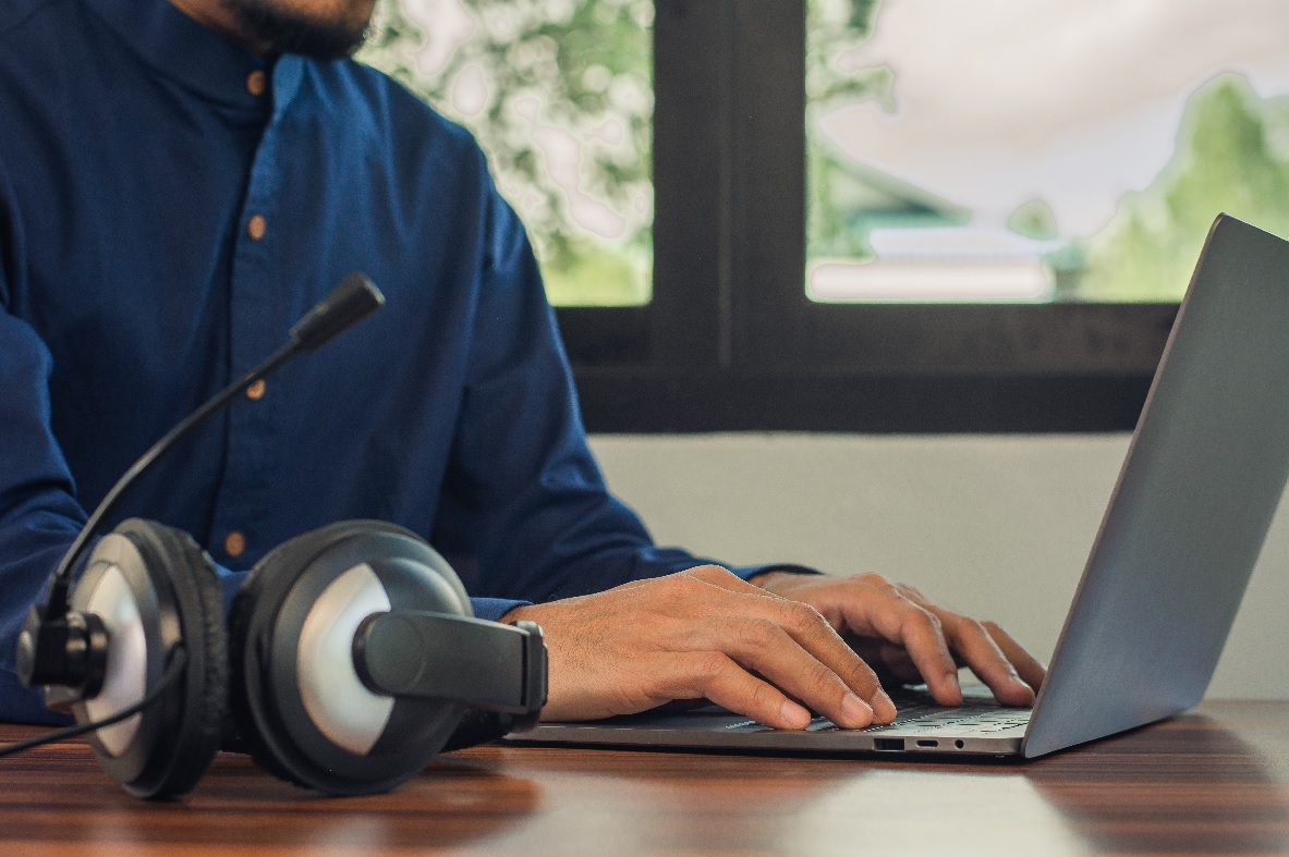 call center agent working on laptop with headphones on table